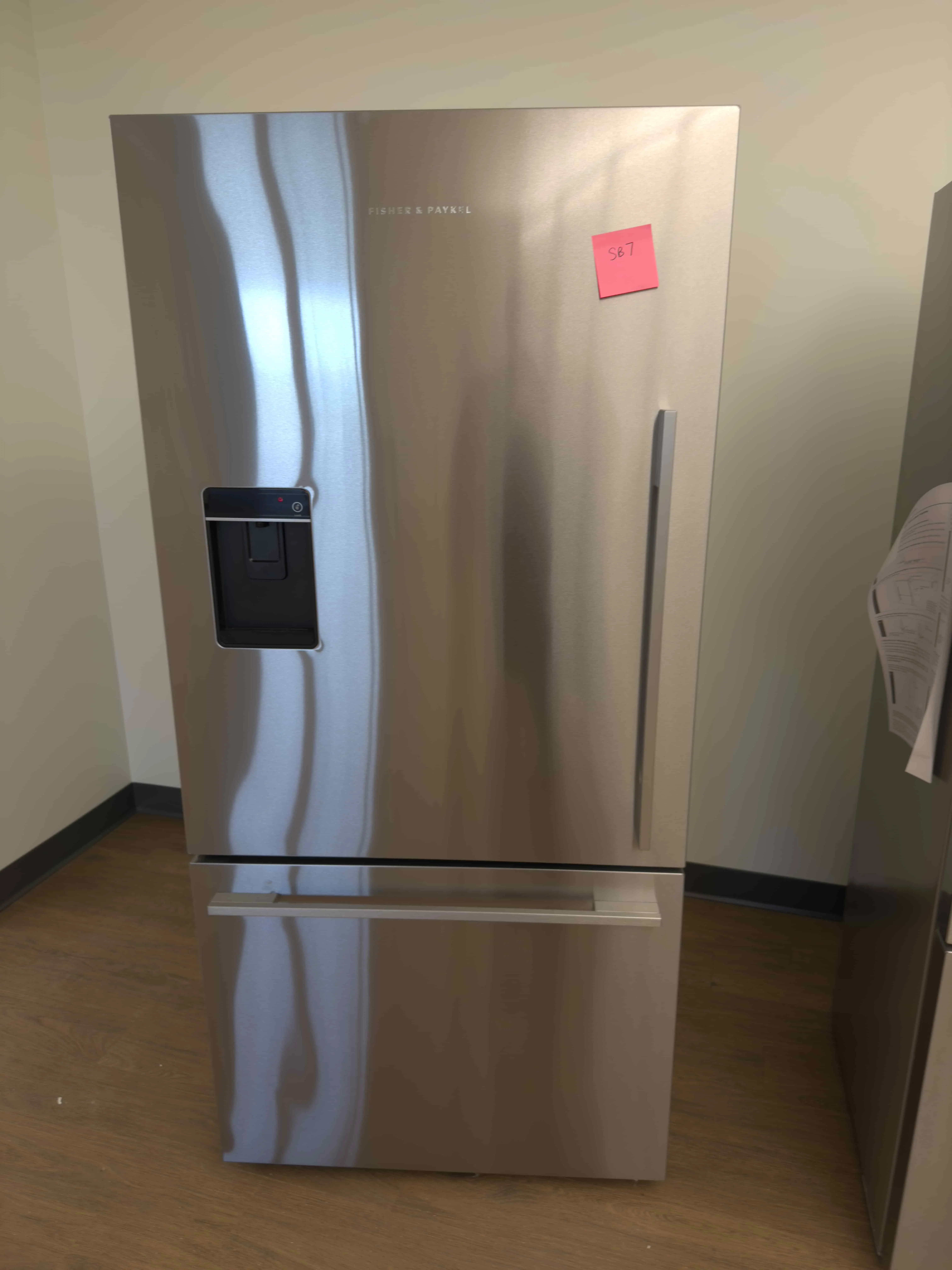 SB07: Fisher & Paykel stainless refrigerator with bottom freezer drawer and external water dispenser.