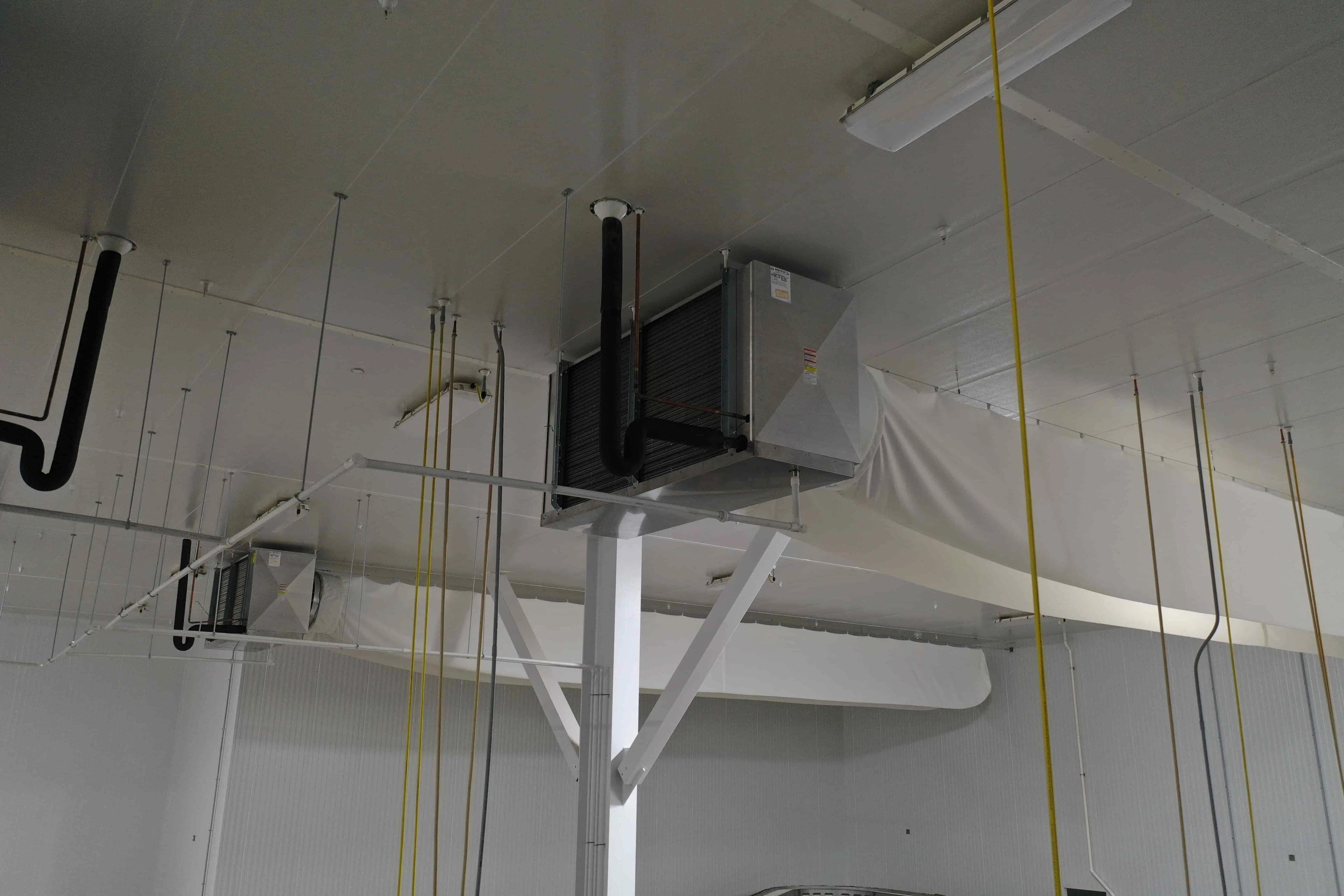 SB6023b: EVAP 2B Evaporative Cooler – Trenton THP106ME-T4A-SN Dual-Fan High-Profile Evaporator with Fabric Duct (~15 000 CFM, 460 V 3-Phase) – EVAP 2B Located Mid-South Wall of 37 °F Cold Pack Room