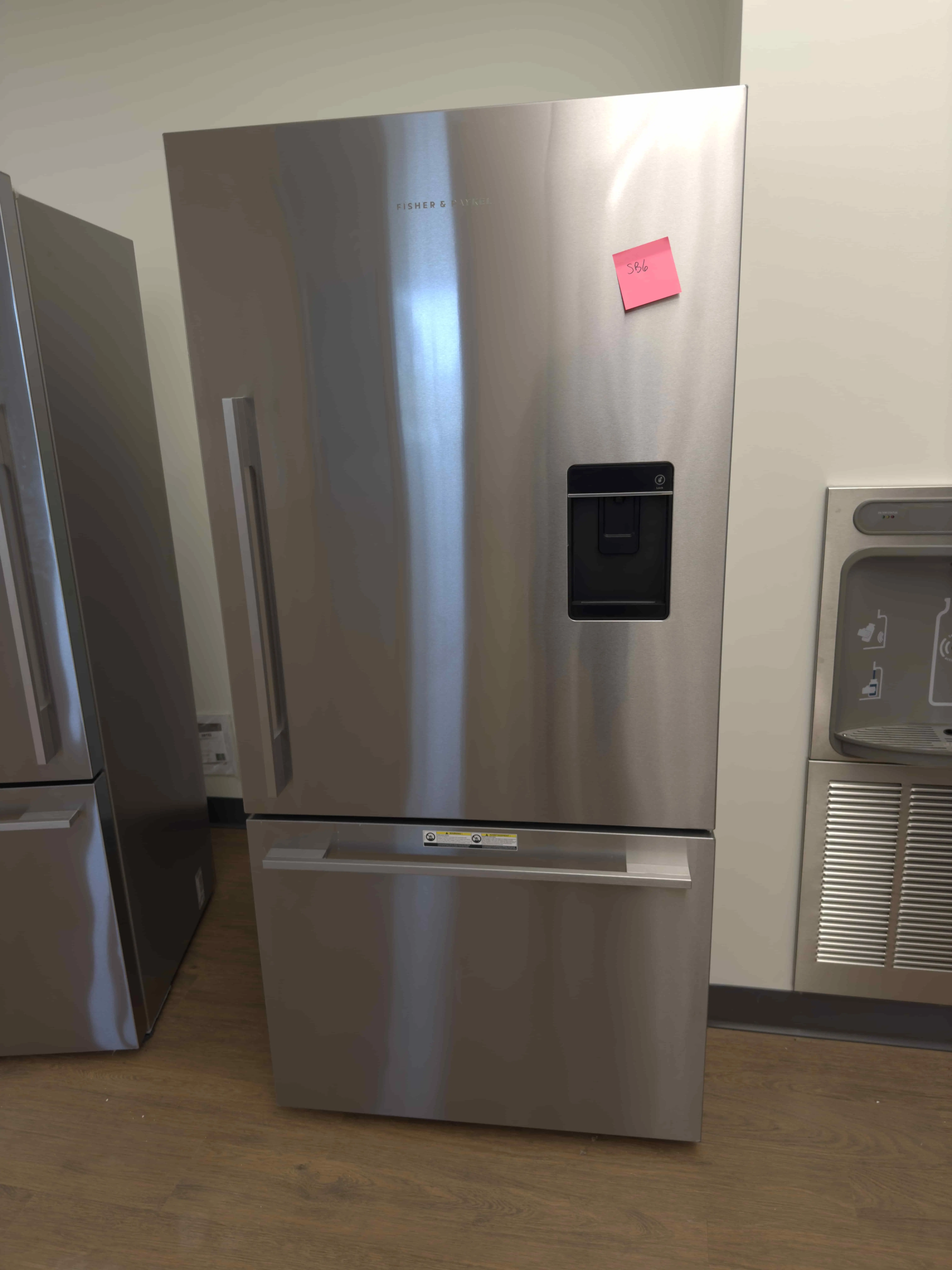 SB06: Fisher & Paykel stainless refrigerator with bottom freezer drawer and external water dispenser.